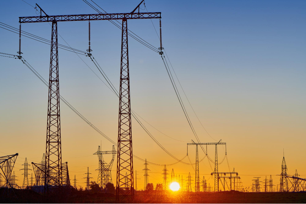 Powerlines silhouetted against a vibrant sunset, highlighting the essential infrastructure maintained by Osmose Utilities Services to ensure reliable utility operations across communities.