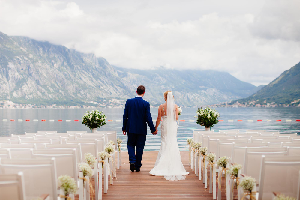 Photo wedding couple at destination wedding ceremony. mountains and sea view in montenegro. picturesque wedding location.
