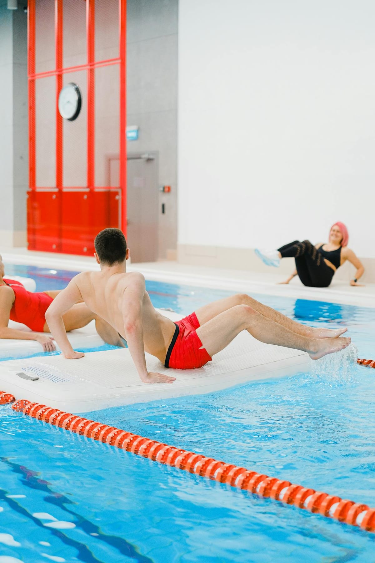 People Exercising on Floating Boards in a Swimming Pool