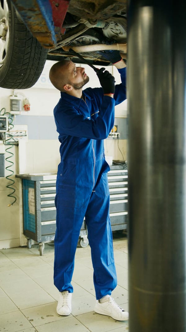 A skilled mechanic works on car maintenance in a professional garage setting.