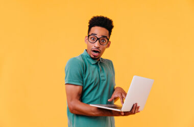 Shocked african student posing while doing homework. disappointed brunette web-developer.