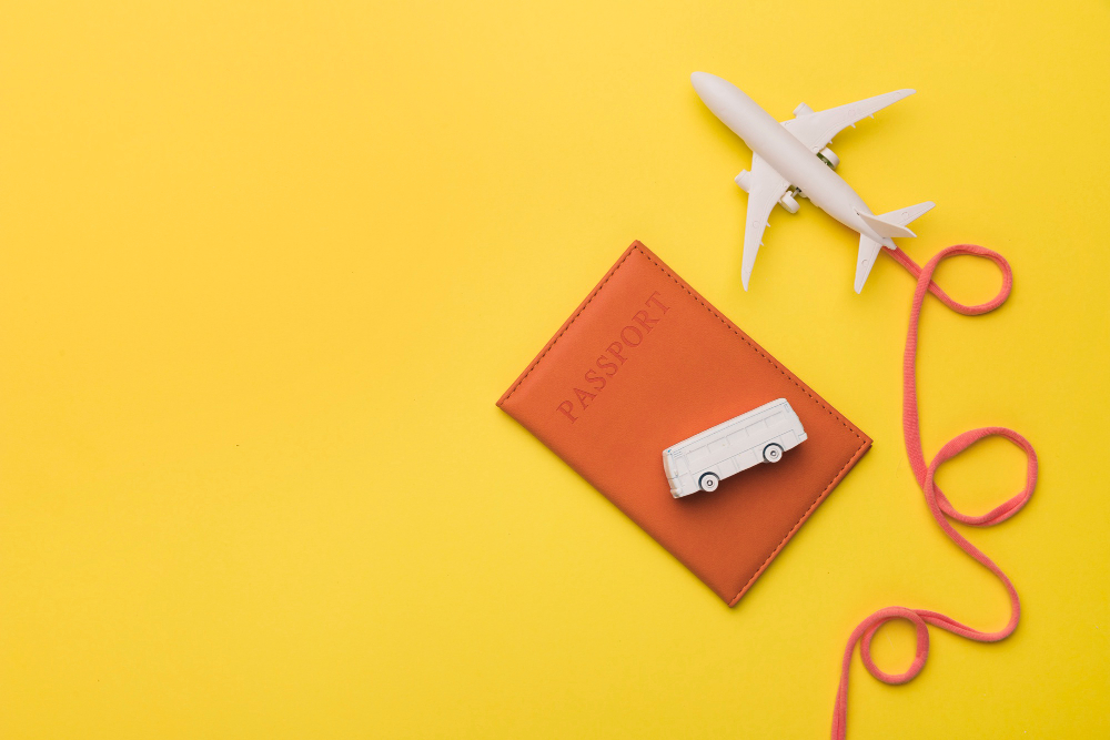 Free photo composition of toy jet with airline passport and bus
