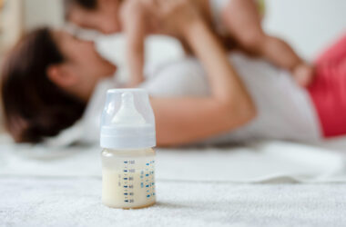 Free photo baby formula with mom and baby in the background