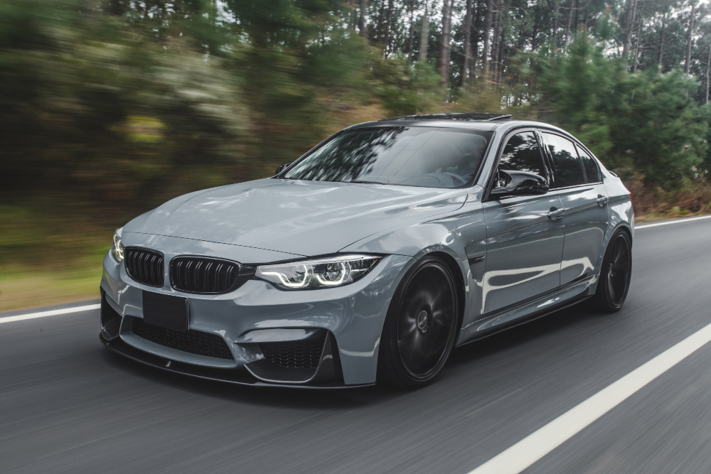 silver metallic color sport sedan on the road.