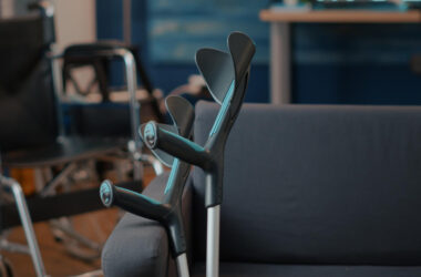 Crutches on empty couch in living room to give mobility support to people with chronic disability or injury. walking sticks helping with transportation and physical accessibility. walk crutch