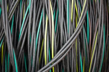 Reel with electric cable. Coil of electrical industrial wire, cable.Cable wire winding. Coiled insulated cable, background.