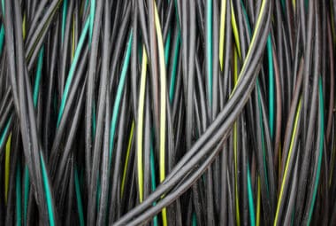 Reel with electric cable. Coil of electrical industrial wire, cable.Cable wire winding. Coiled insulated cable, background.