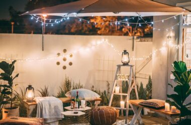 Charming outdoor patio scene with cozy seating and warm lighting at night.